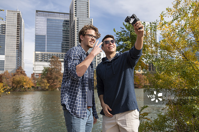 两个年轻的朋友（拉丁裔和白人）用运动相机录制视频博客图片素材