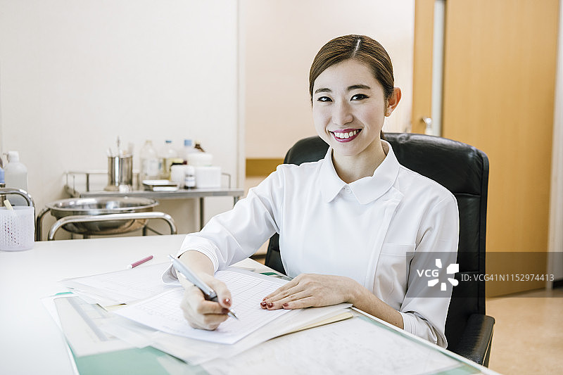 在病历上做笔记的女护士肖像图片素材