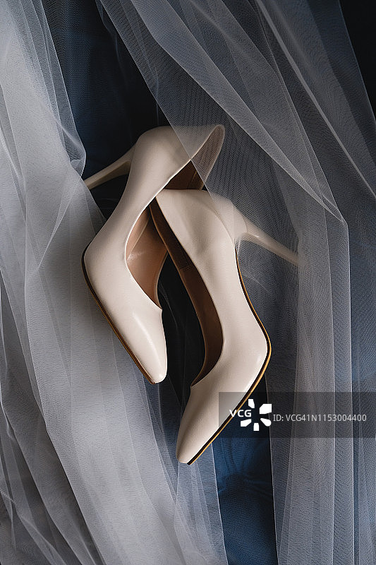 米色婚鞋：新娘在天鹅绒沙发上的婚鞋图片素材