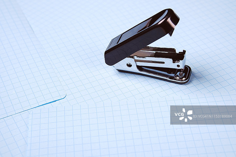 白色背景上的黑色订书机，桌面上的学校和办公用品，留白区域，学校和学前教育理念，办公室工作，工作场所特写图片素材