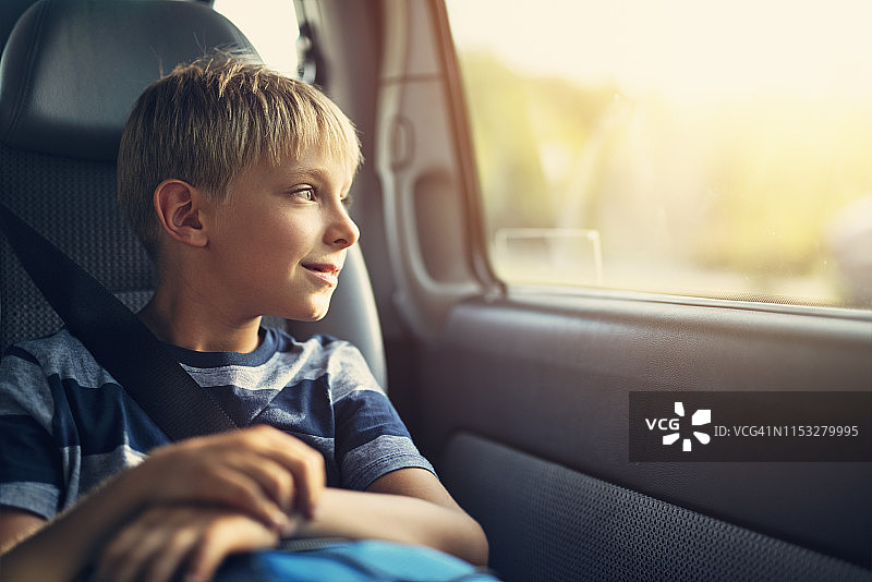 面带微笑的小男孩坐在汽车儿童座椅上图片素材