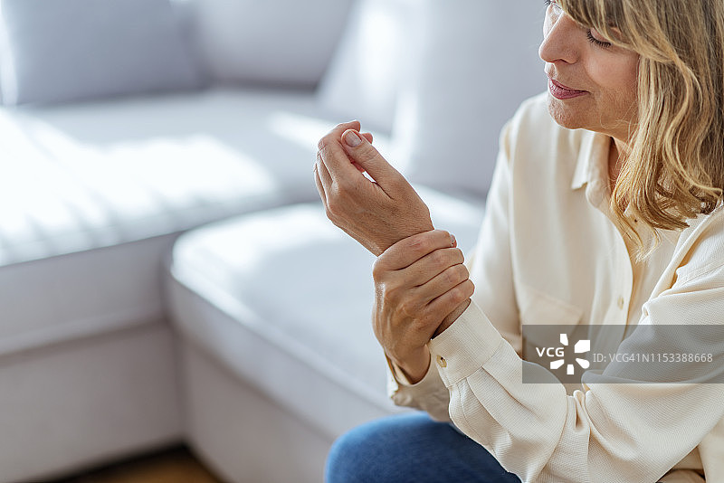 在家中手部疼痛的中年妇女图片素材