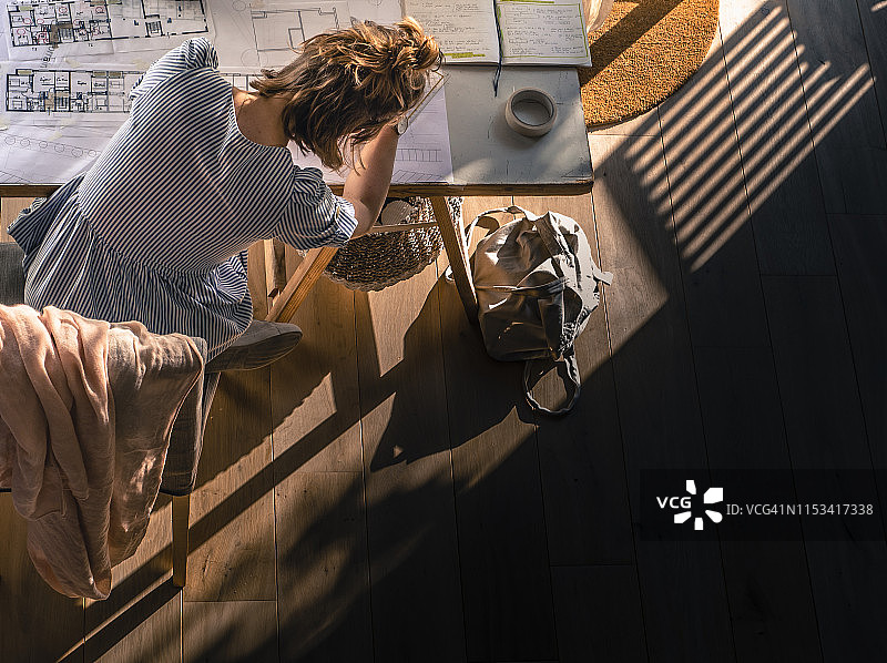 年轻女子俯视绘制建筑设计图图片素材