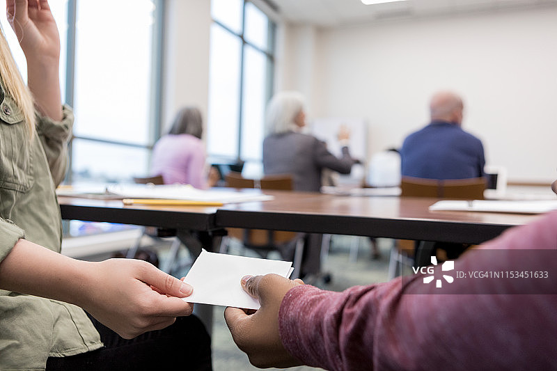 少女在课堂上传纸条给男友图片素材