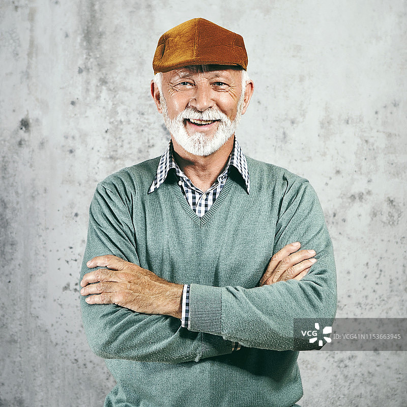 穿着毛衣和贝雷帽的年长男人摆姿势图片素材