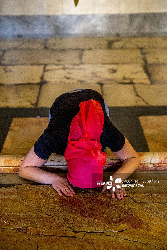 在耶路撒冷圣墓教堂的受膏石上敬拜的基督教朝圣者图片素材