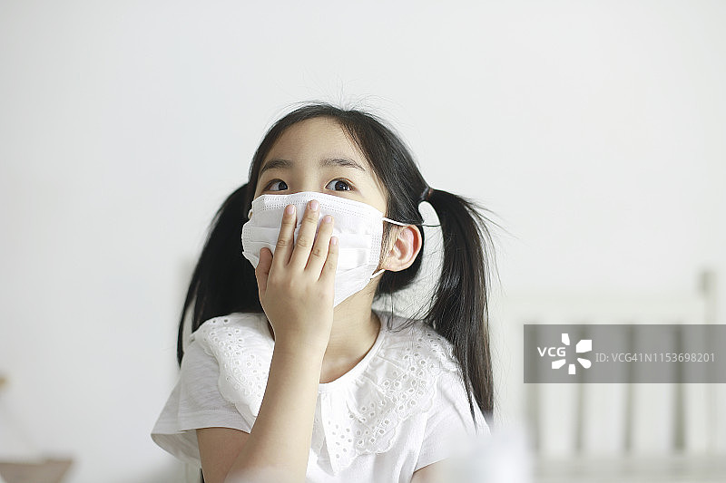 戴着防护口罩咳嗽的女孩图片素材