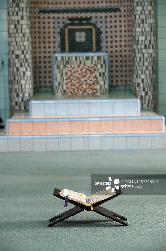 穆巴拉克清真寺。木制支架上打开的古兰经，背景是敏拜尔。朱笃，越南。图片素材