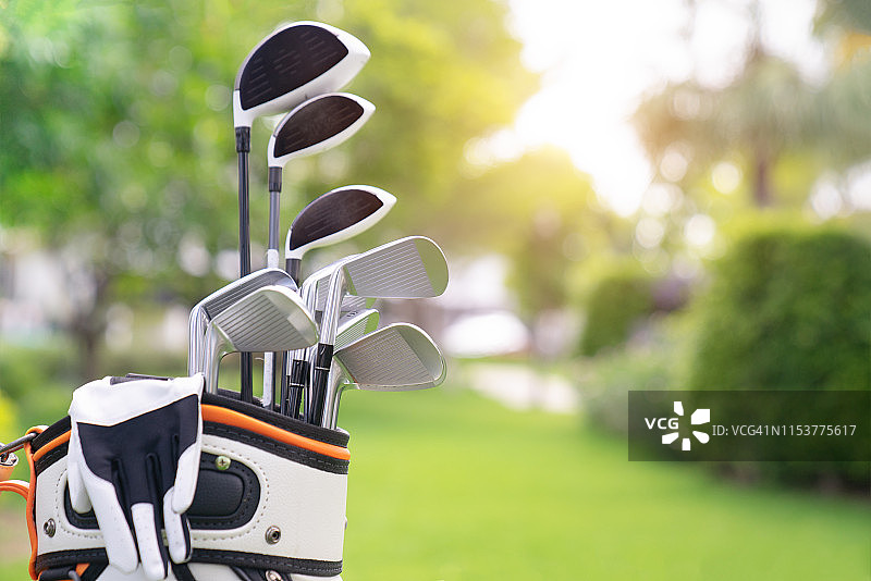 绿色球场背景上的高尔夫球杆套装图片素材