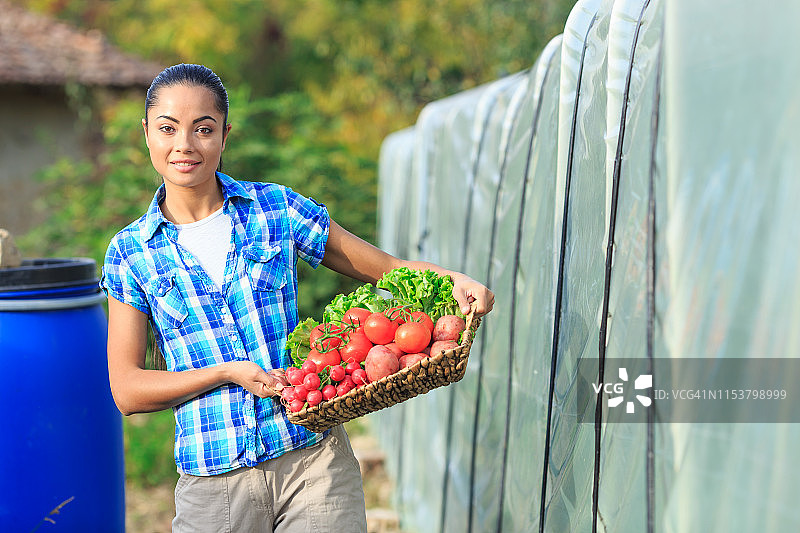 拿着装满蔬菜篮子的年轻女人图片素材