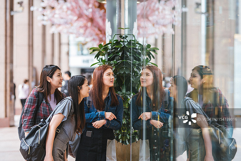 拎着购物袋在街上行走的高兴年轻女孩图片素材