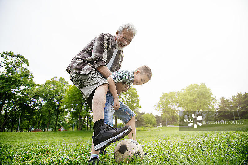 爷爷和孙子玩足球，其乐融融图片素材