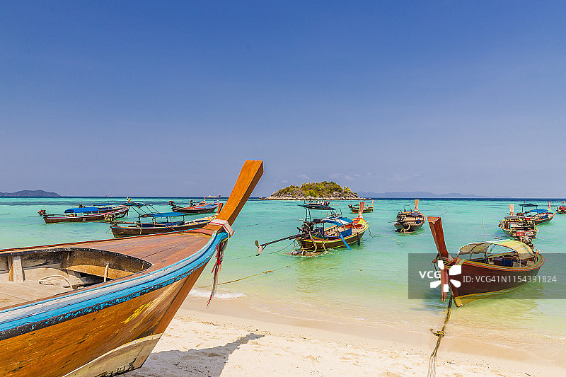 泰国丽贝岛日出海滩上的长尾船图片素材