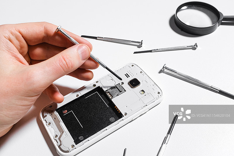 手机维修，白色背景上的手部特写图片素材