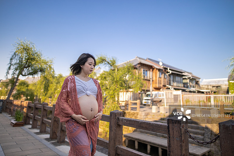 走在日本传统村庄的怀孕少女图片素材