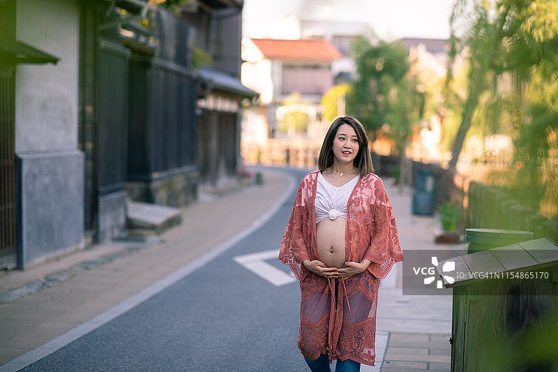 走在日本传统村庄的怀孕少女图片素材