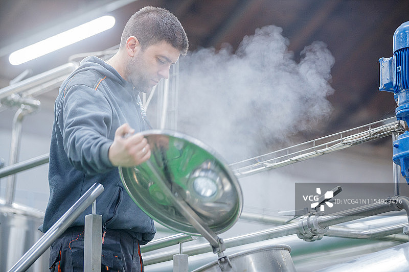 工人打开酿造机的盖子图片素材