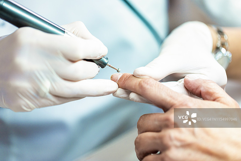 使用美甲旋转锉去除多余角质，修整指甲图片素材