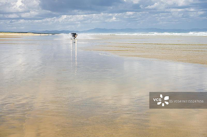 黑色现代胜达四驱越野车行驶在新西兰北岛沙滩上图片素材
