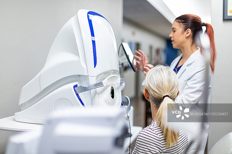 使用先进眼科技术设备的眼科护理专业人员图片素材