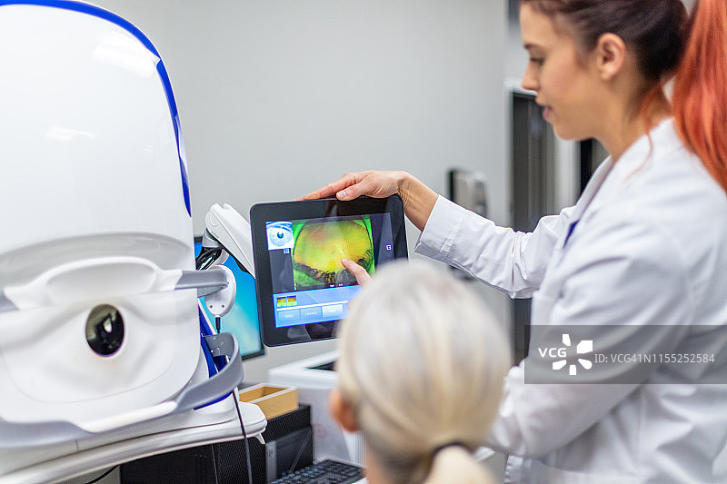 使用先进眼科技术设备的眼科护理专业人员图片素材