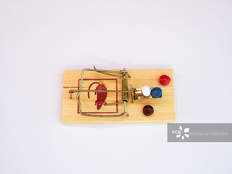 装满彩色巧克力糖果的老鼠夹：诱惑与沉迷的概念图片素材