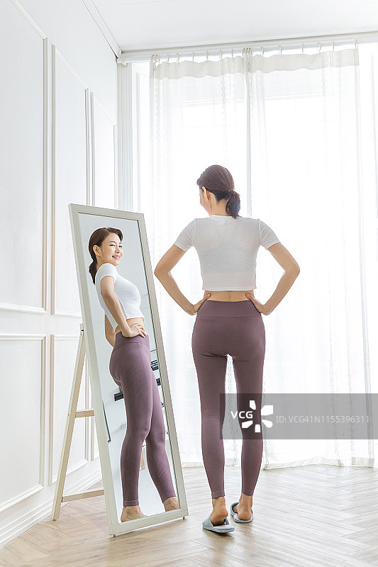 通过镜子检查自己身体的女人图片素材