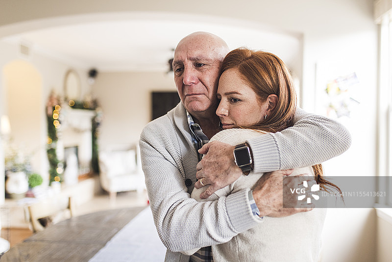 父亲拥抱成年女儿，眼含热泪的肖像图片素材