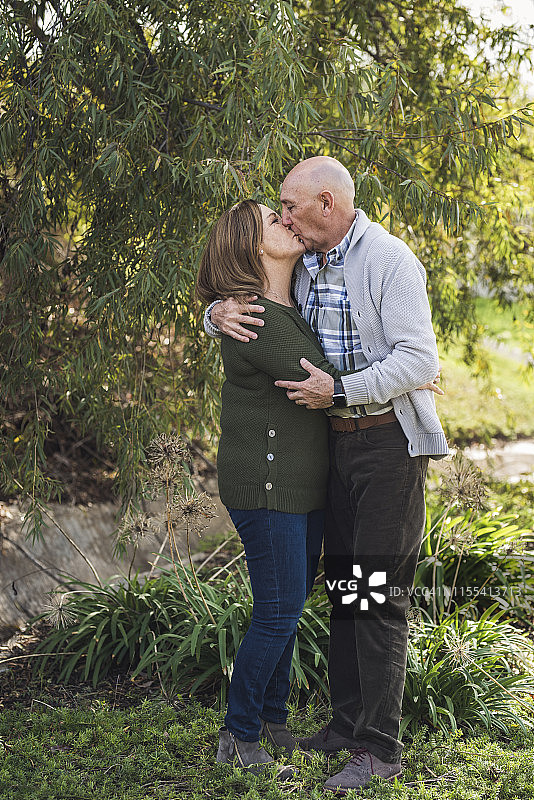 在户外亲吻和拥抱的祖父母肖像图片素材