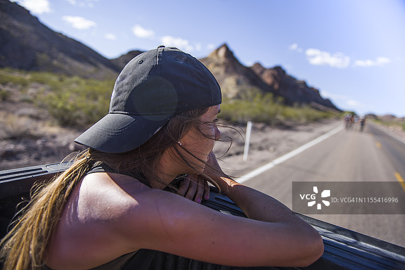 年轻女子在卡车后部欣赏山景图片素材