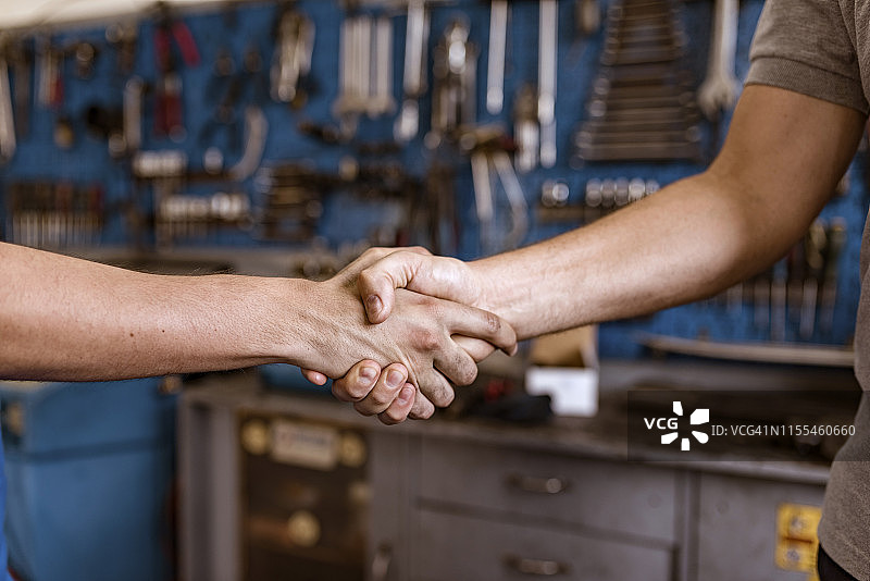 汽车修理店的机械师握手图片素材