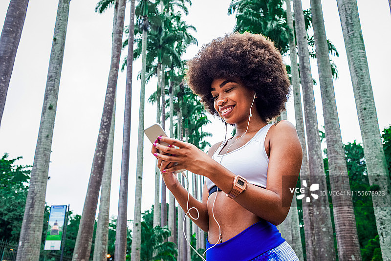 训练间隙使用智能手机的年轻女人图片素材