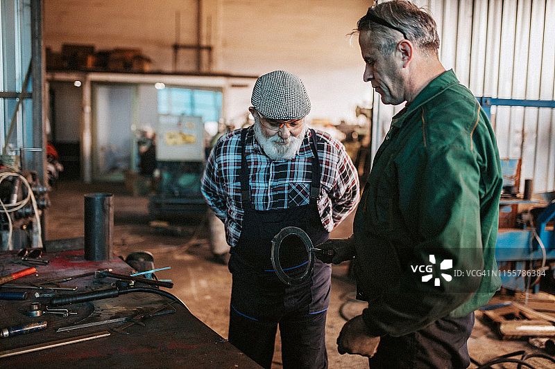 一位老人正在切割金属图片素材