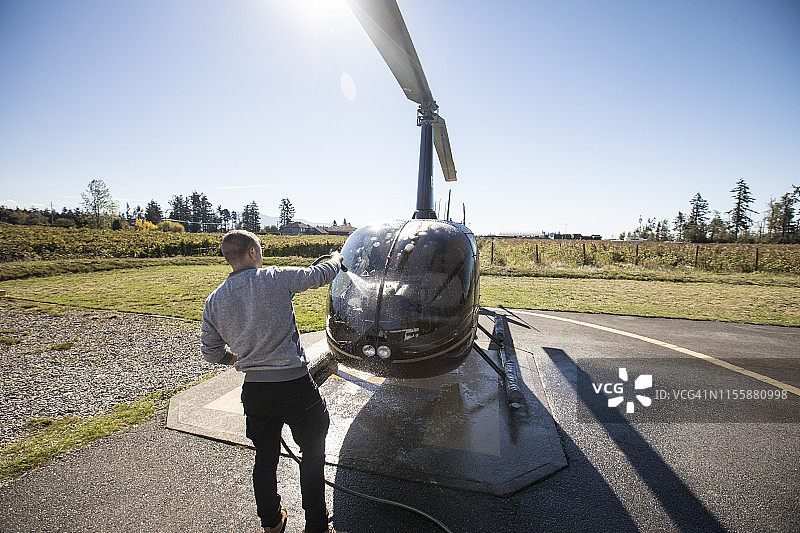 飞行员在飞行一天后维护和清洗他的直升机图片素材