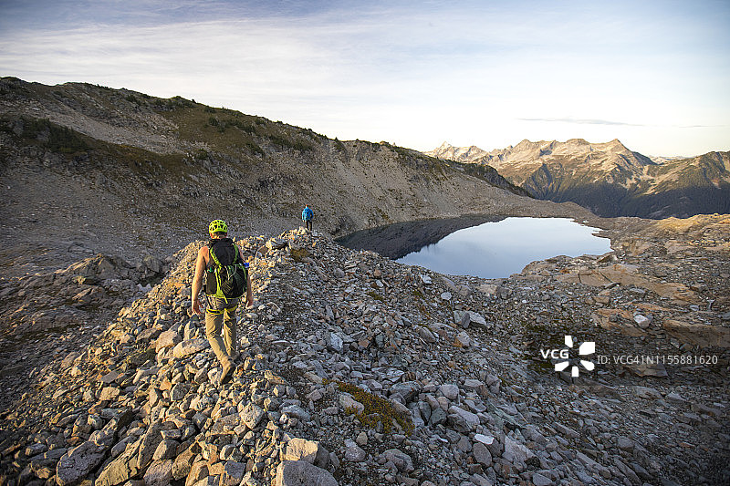 两名背包客走向不列颠哥伦比亚省的阿尔卑斯山高山湖泊，加拿大图片素材