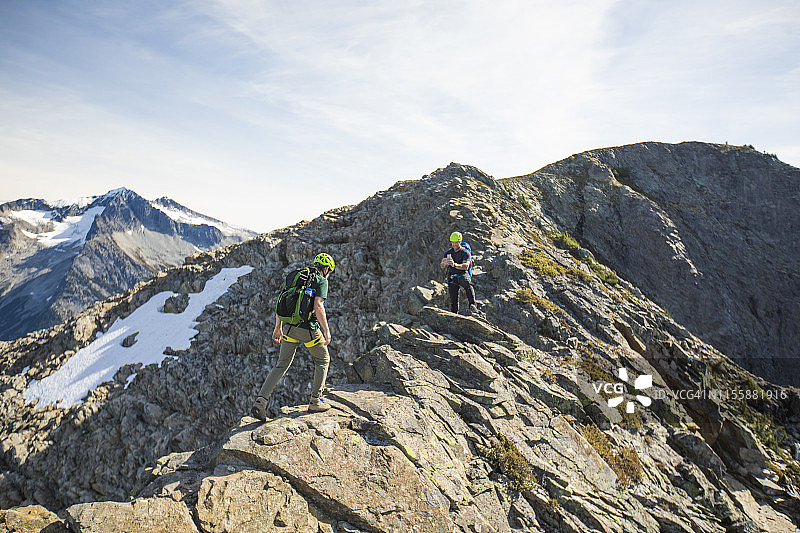 登山者穿越不列颠哥伦比亚省道格拉斯峰顶附近的狭窄山脊图片素材