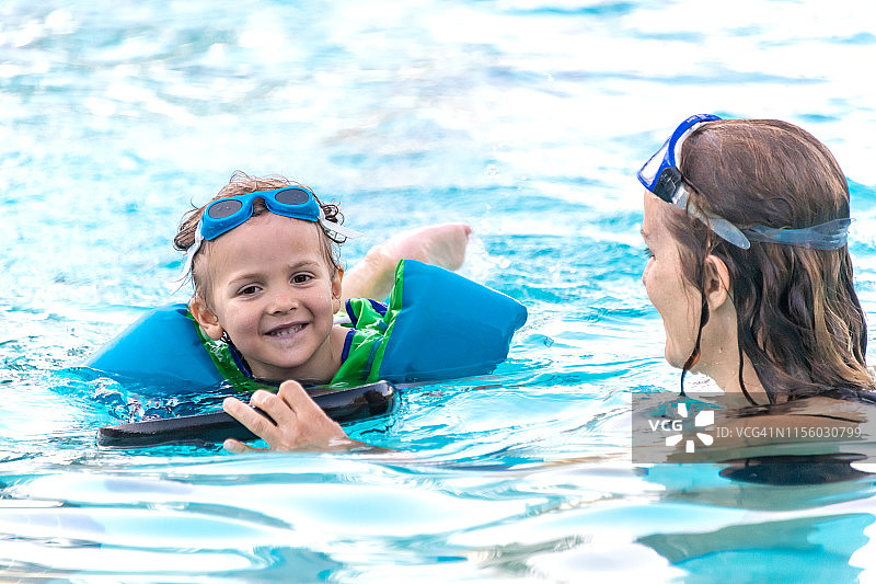 中年妇女在游泳池里和儿子玩耍图片素材