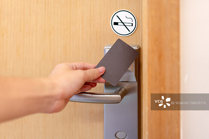 一个年轻人正在用房卡开门图片素材