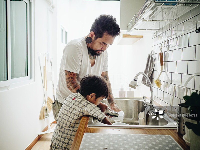 帮助父亲做家务的亚洲男婴图片素材