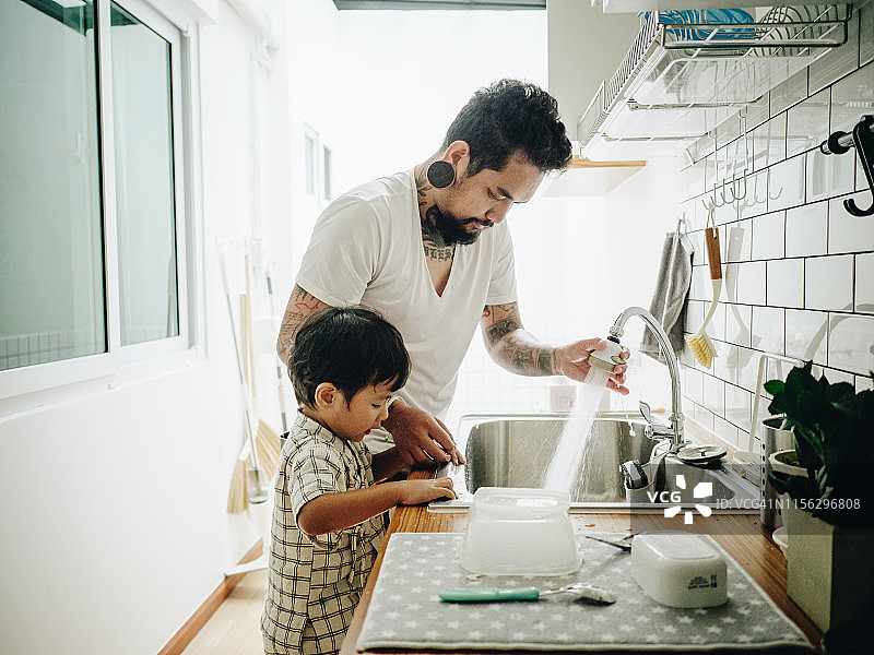 帮助父亲做家务的亚洲男婴图片素材
