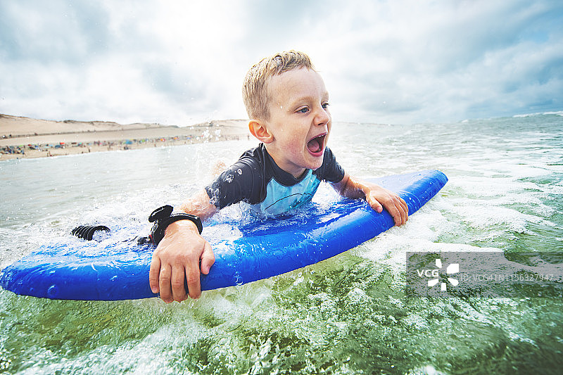在海边玩趴板的小男孩图片素材
