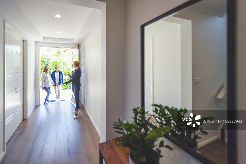 房产中介向一对年轻夫妇展示新房图片素材