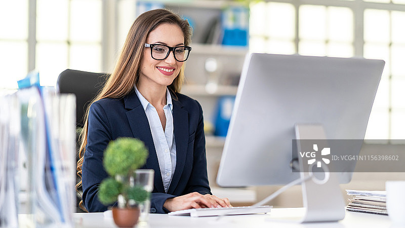在办公室用电脑工作的女商人肖像图片素材