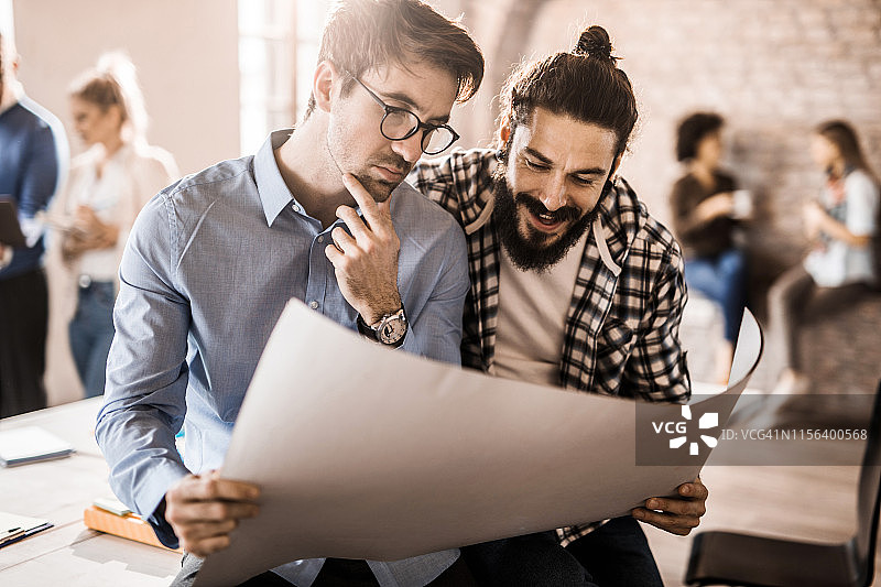 年轻男建筑师在办公室分析蓝图图片素材