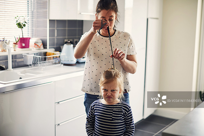 女人为小女孩梳理头发图片素材