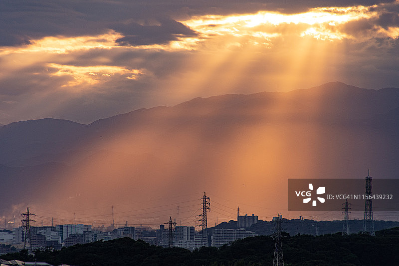 落日的阳光照在日本的住宅区和山上图片素材