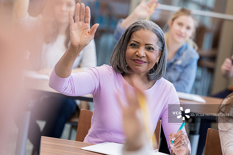 中年妇女举手回答课堂问题图片素材