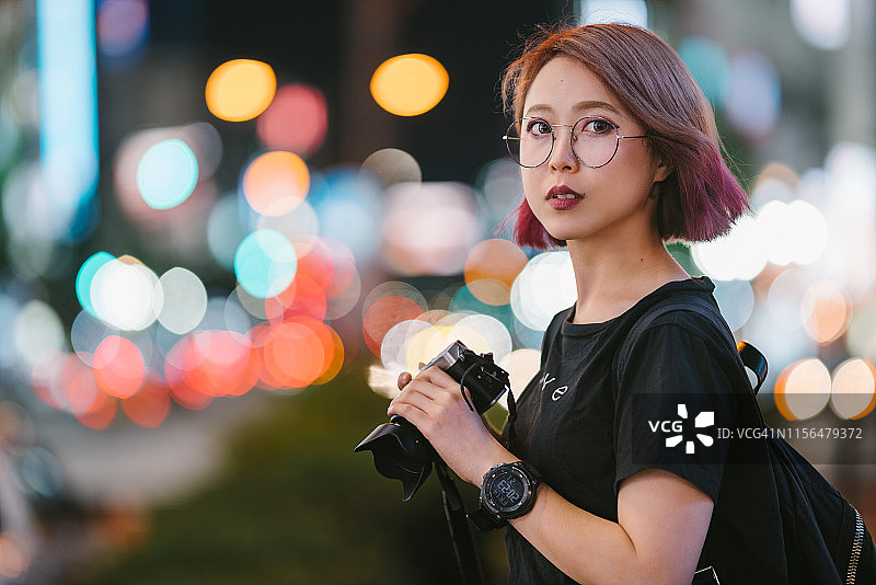 晚上拿着相机的年轻女人图片素材