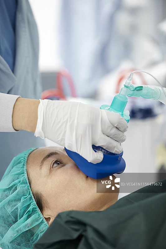 女护士为病人戴氧气面罩图片素材