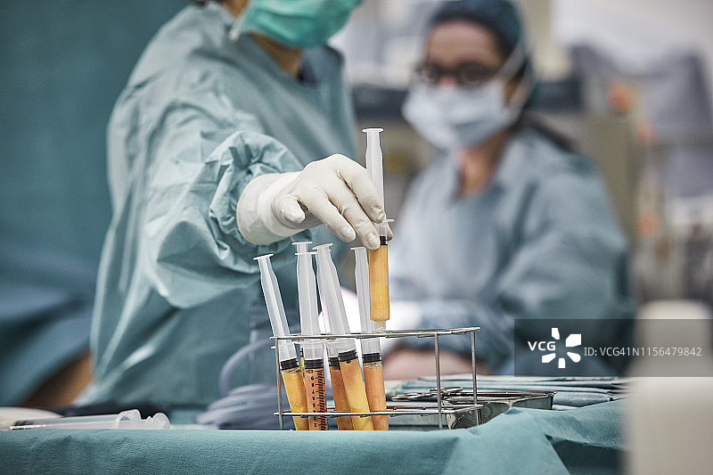 拿着脂肪注射器的女外科医生图片素材